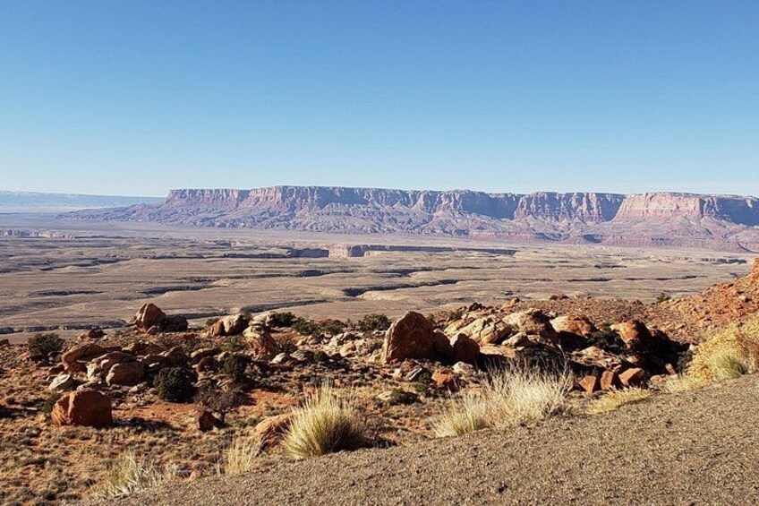A desert landscape with rocky terrain and distant mountain ranges. 2