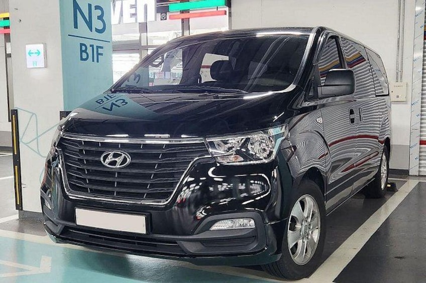 A black Hyundai van parked indoors with a visible license plate. 3