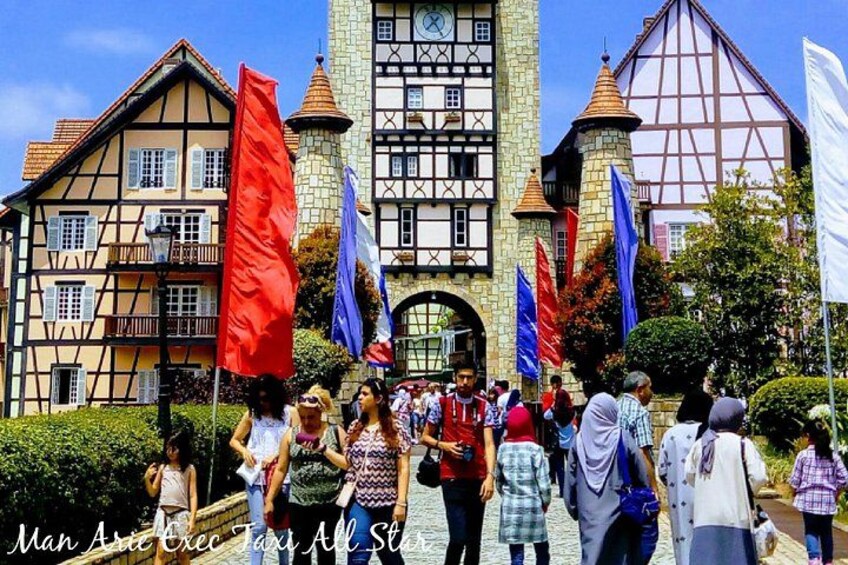 A group of people in front of a historic building with a clock tower and multiple flags. 1
