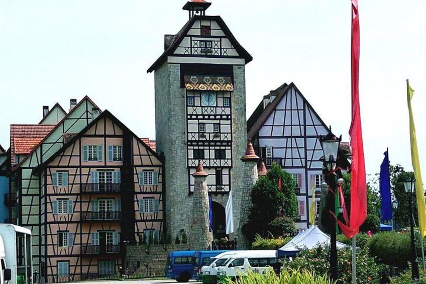 Traditional half-timbered houses, a stone tower, and flags. 4
