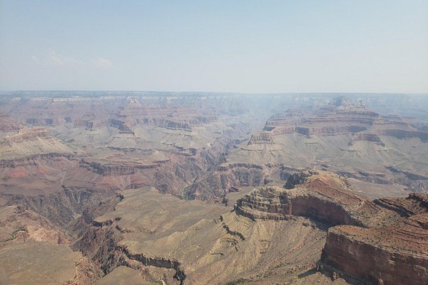A vast canyon landscape with layered rock formations and a clear sky. 2