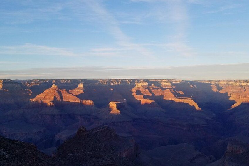 Et stort canyonlandskab med lagdelte klippeformationer og en klar himmel. 4