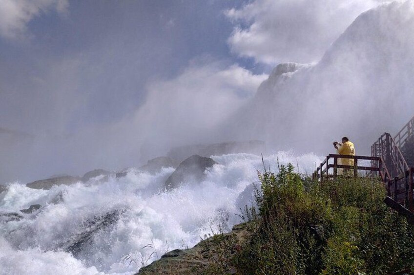 Una persona observando olas oceánicas agitadas desde un promontorio rocoso. 2