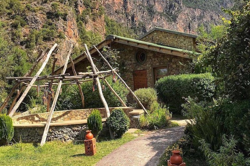 A stone house with a wooden structure in a mountainous area. 4