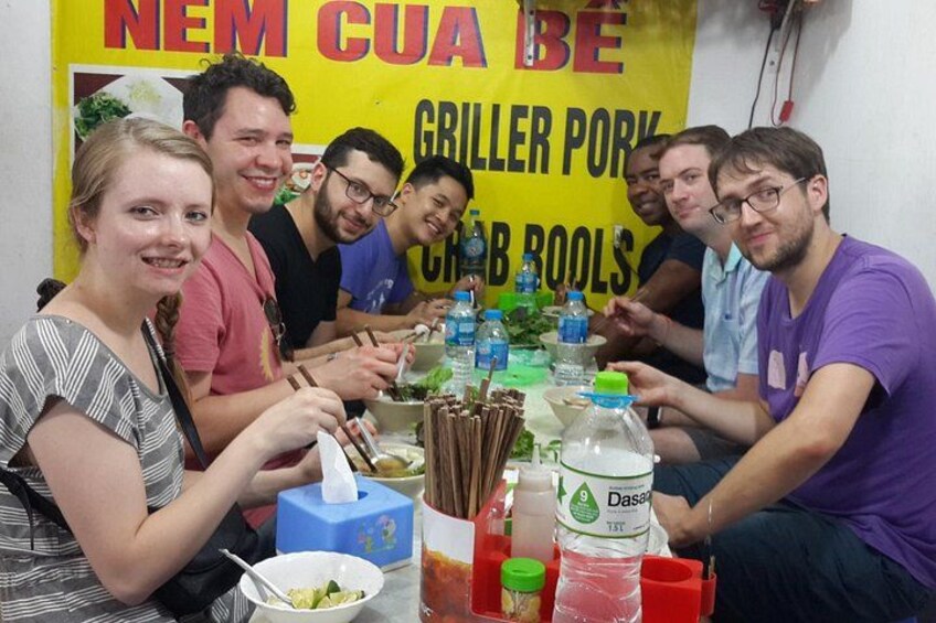 A group of people sitting around a table with food and drinks. 4