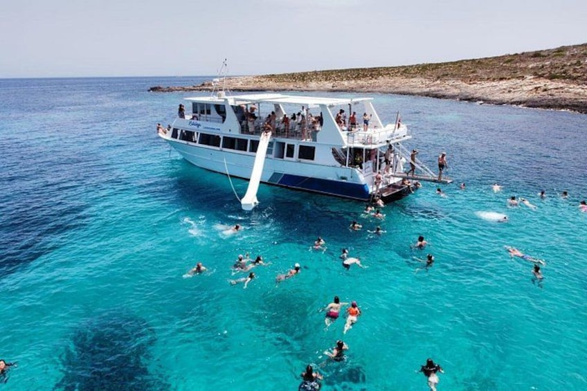 A boat with people swimming in the water. 2
