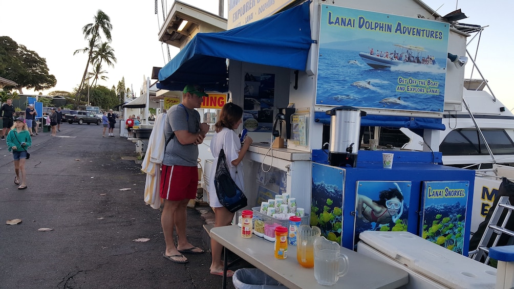A food stall with a sign for 'Lanai Dolphin Adventures' and a 'Lanai Snorkel' sign. 5