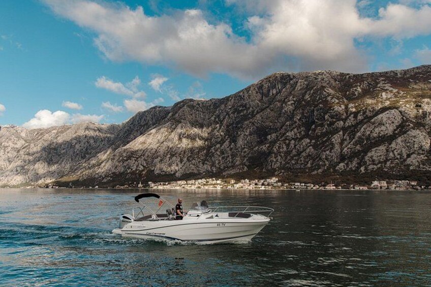 A boat on calm water with a mountainous backdrop. 2