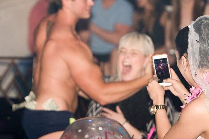 Una persona tomando una foto con un teléfono inteligente, otra persona al fondo, y una persona con el rostro desenfocado. 2