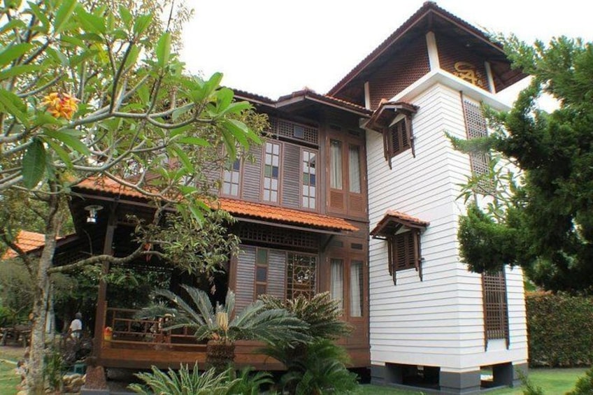 A traditional house with a tiled roof, wooden balconies, and a white exterior. 2
