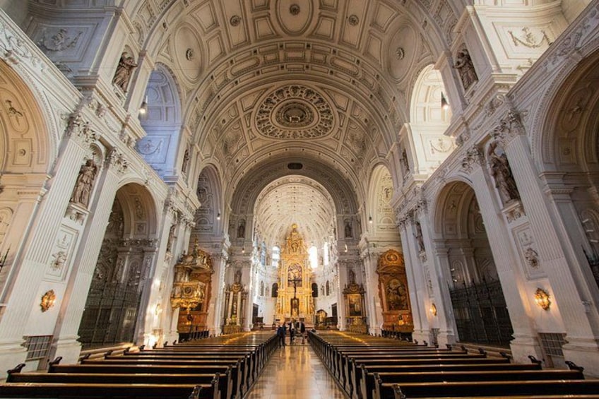 An ornate church interior with high ceilings, detailed carvings, and rows of pews. 5