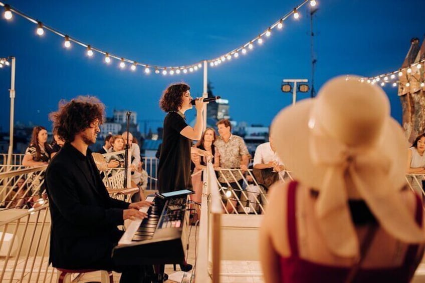 A live music performance at night with string lights and a seated audience. 3