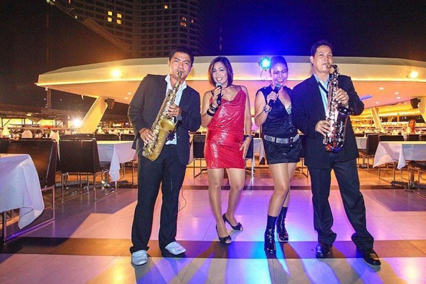 A group of four people performing on a stage with musical instruments. 5
