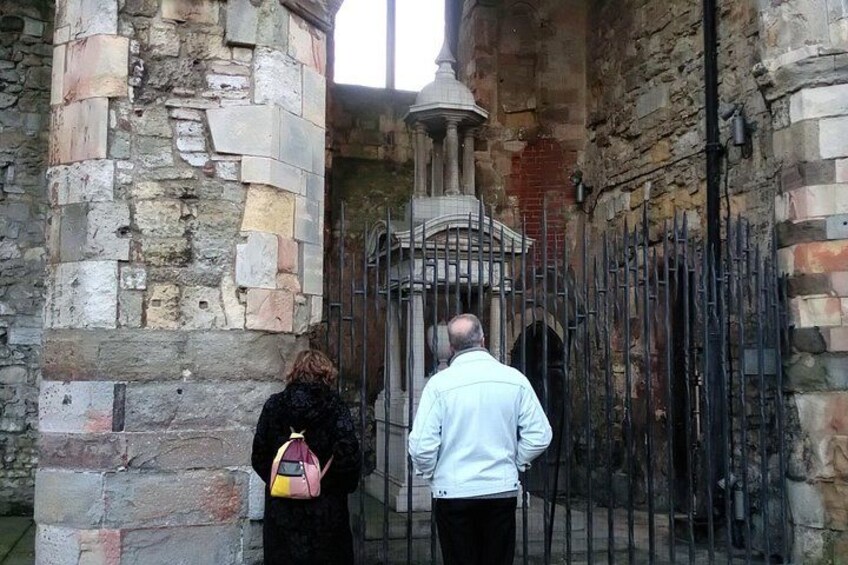 A stone building with a metal gate and a bell tower. 4