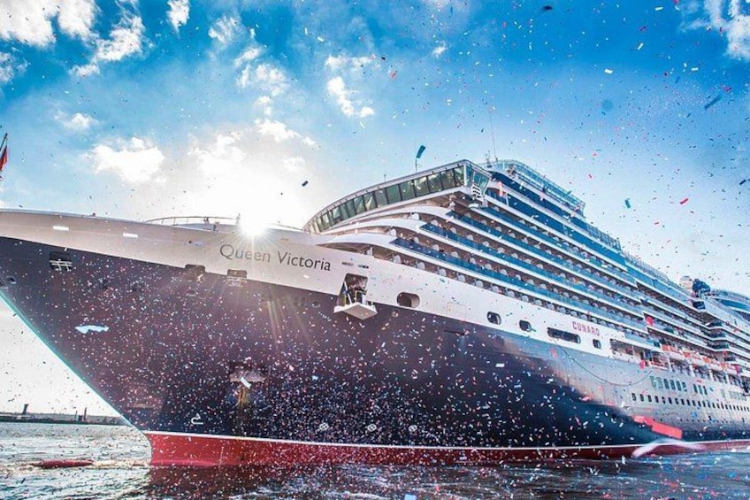 A large cruise ship named Queen Victoria sailing on the water. 2