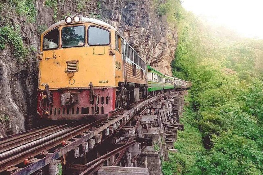 A yellow train on a bridge over a canyon. 2