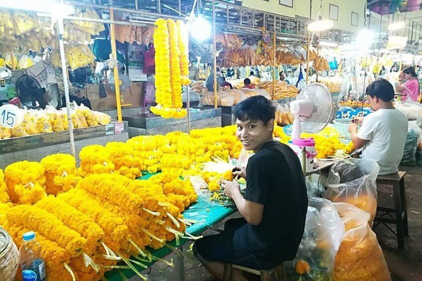 A market with yellow flowers and people working. 5