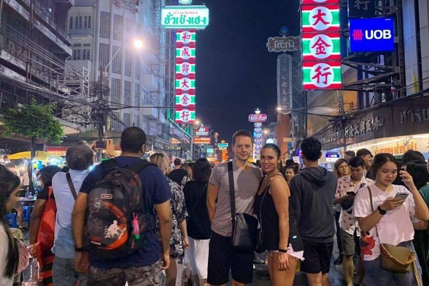 A crowded street at night with illuminated signs and buildings. 2