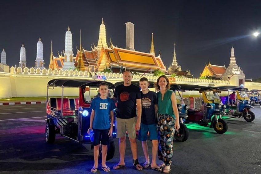 A family standing in front of a temple with traditional architecture. 1