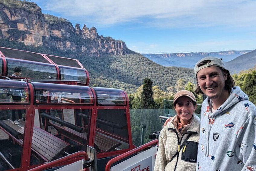 A cable car with passengers, a mountainous landscape, and a clear sky. 5