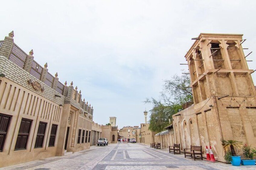 A street with historic buildings, a clock tower, and a mosque in the distance. 1