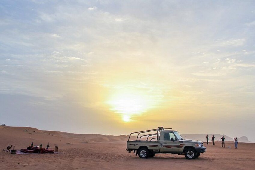 A desert landscape with a truck, dunes, and people. 3