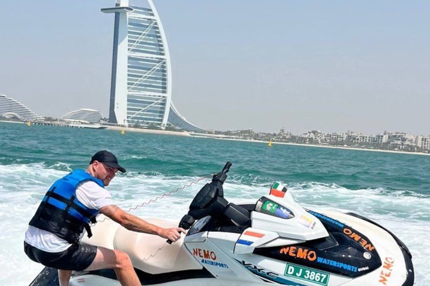 Una persona en un jet ski, con un puente al fondo. 5