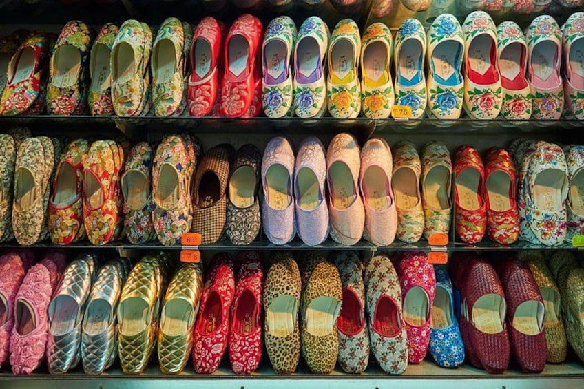 Eine Auswahl bunter, gemusterter Schuhe, präsentiert auf Regalen. 5