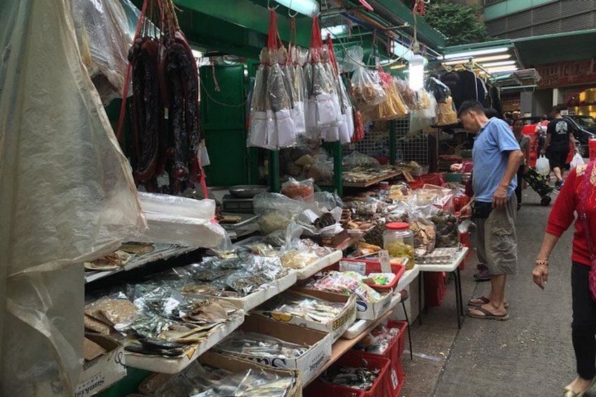 A market stall with various food items, including seafood and packaged goods. 1