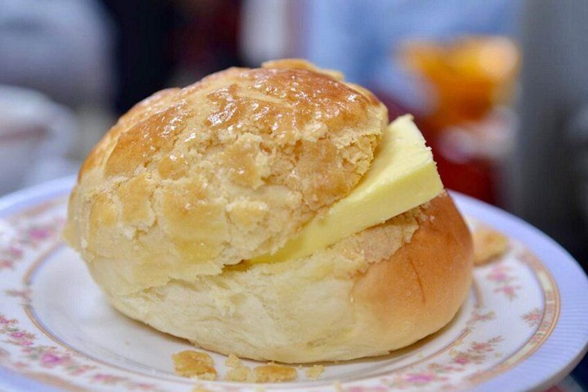 A buttered bun on a floral plate. 5