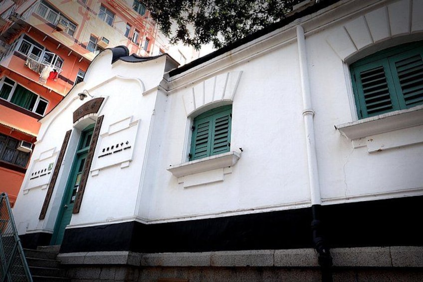 A white building with green shutters and a sign that reads 'Hotel'. 3