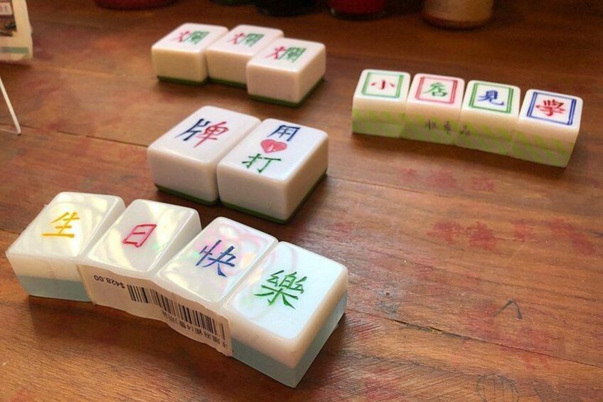 A set of Mahjong tiles on a wooden table. 2