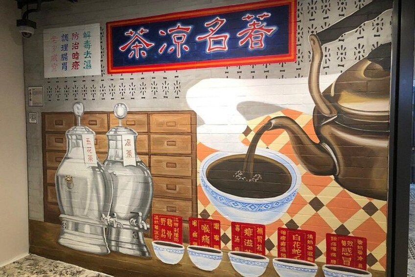 A mural with a teapot pouring tea, traditional Japanese ceramics, and a sign with Japanese characters. 3