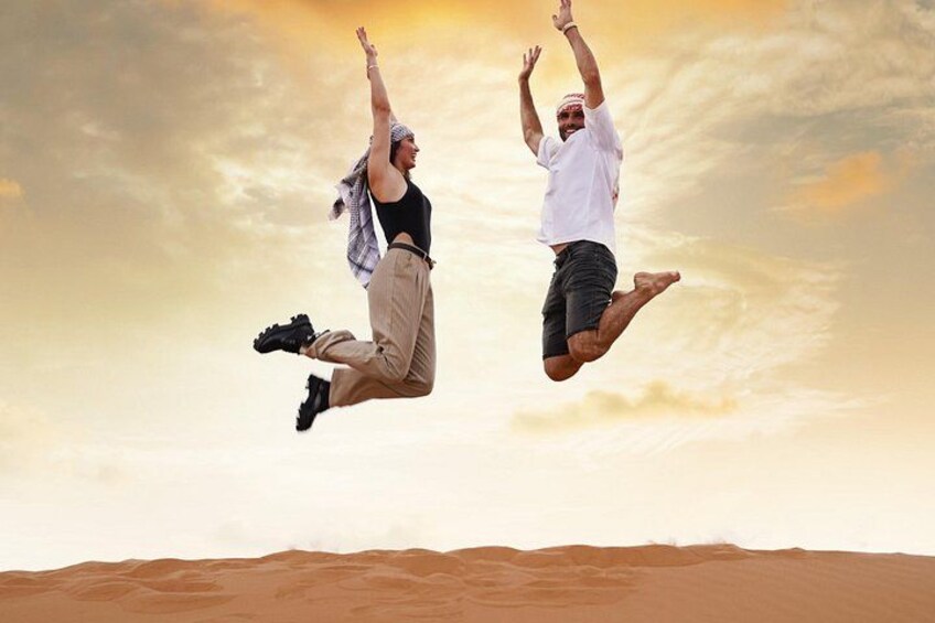 Two people jumping in the air above a desert landscape. 3