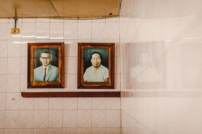 Two framed portraits on a tiled wall. 3