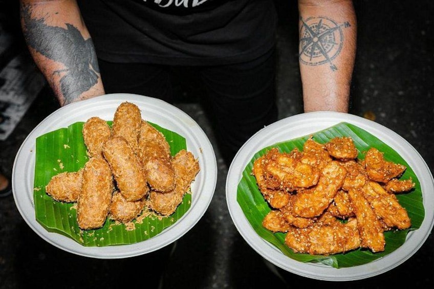 Two plates of fried chicken on banana leaves. 5