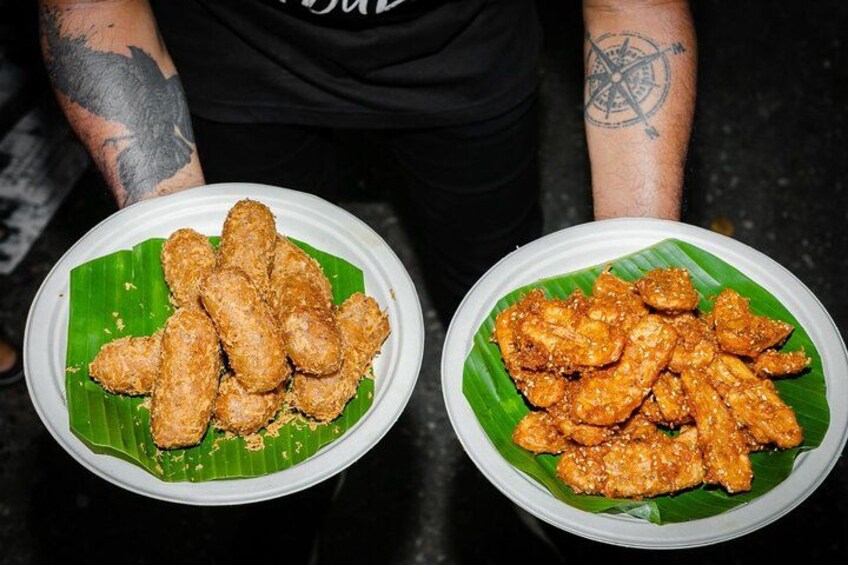 Two plates of fried chicken wings on banana leaves. 4