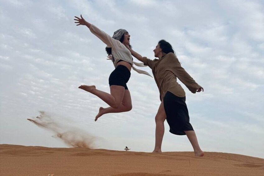 Dos personas saltando sobre una duna de arena. 2