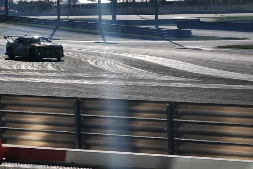 Un auto de carreras en una pista, con una barrera al frente. 2
