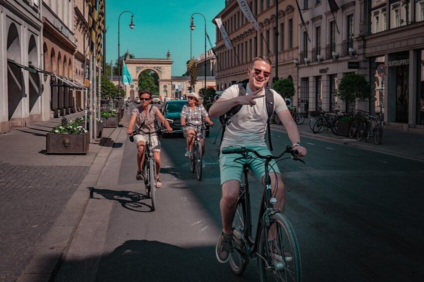 A street scene with cyclists, buildings, and a clear sky. 5