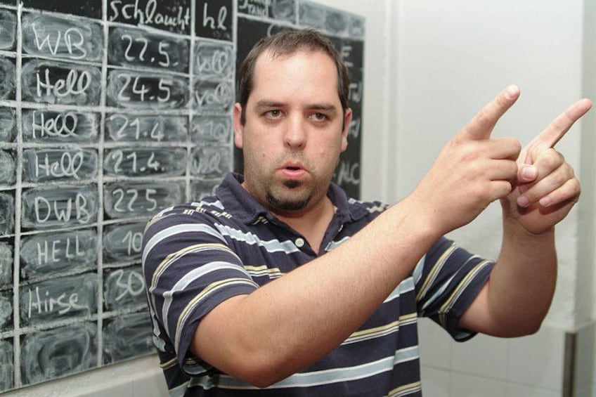 A person pointing at a wall with chalk writings. 2