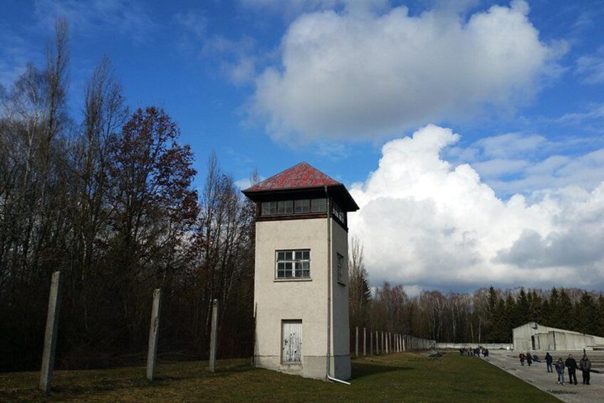 Una torre blanca con techo rojo, rodeada de árboles y un cielo despejado. 4