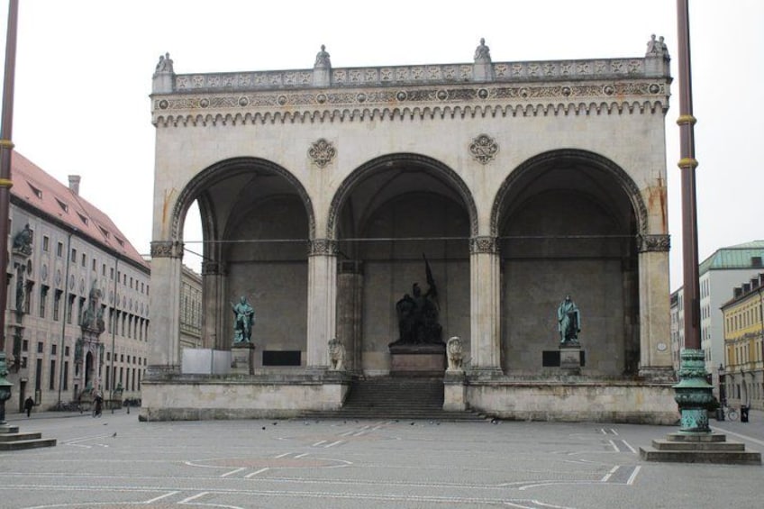 Un arco de piedra grande y ornamentado con estatuas a cada lado y un relieve central. 2