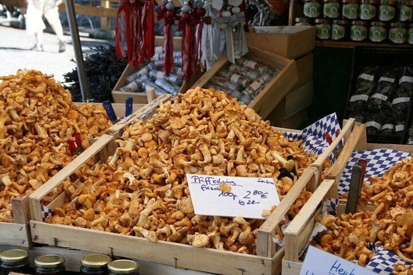 Un puesto de mercado con cajas de madera llenas de hongos. 4