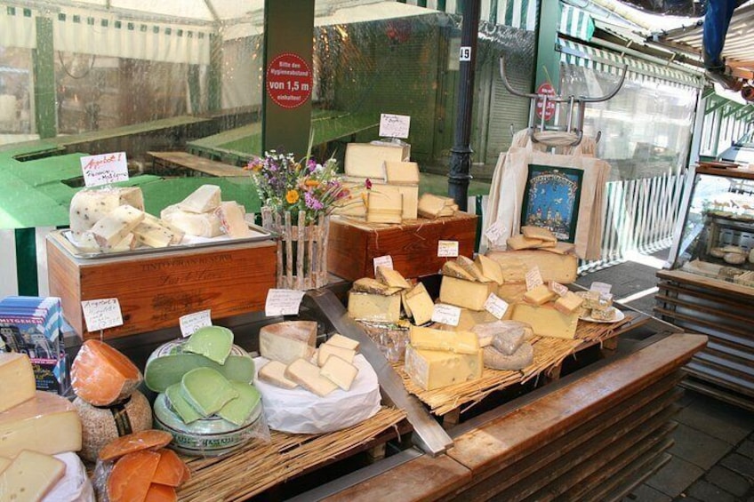 Una exposición de quesos con diferentes tipos de queso en cajas y cestas de madera. 5