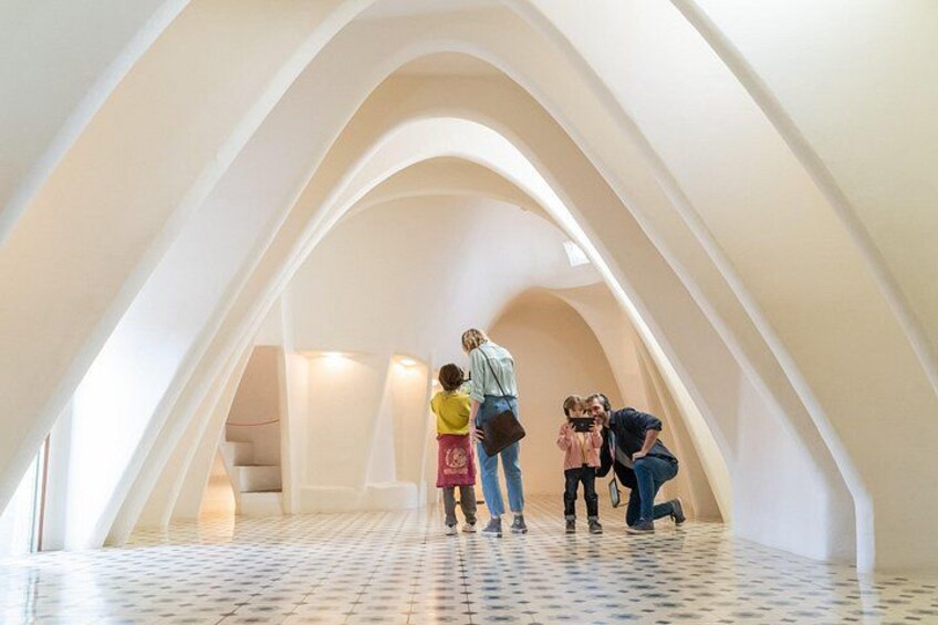An interior with arched ceilings and a tiled floor. 5