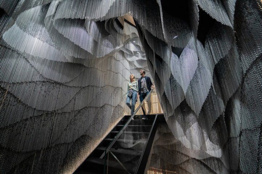 A large, textured wall with a staircase leading up to a platform. 3