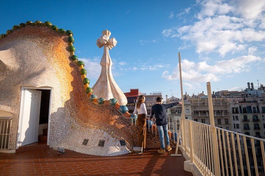 A building with mosaic tiles and a large white sculpture. 2