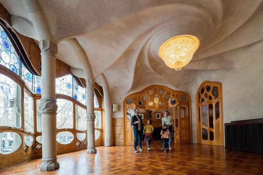 A spacious interior with a high ceiling, large windows, and a central decorative wall. 4