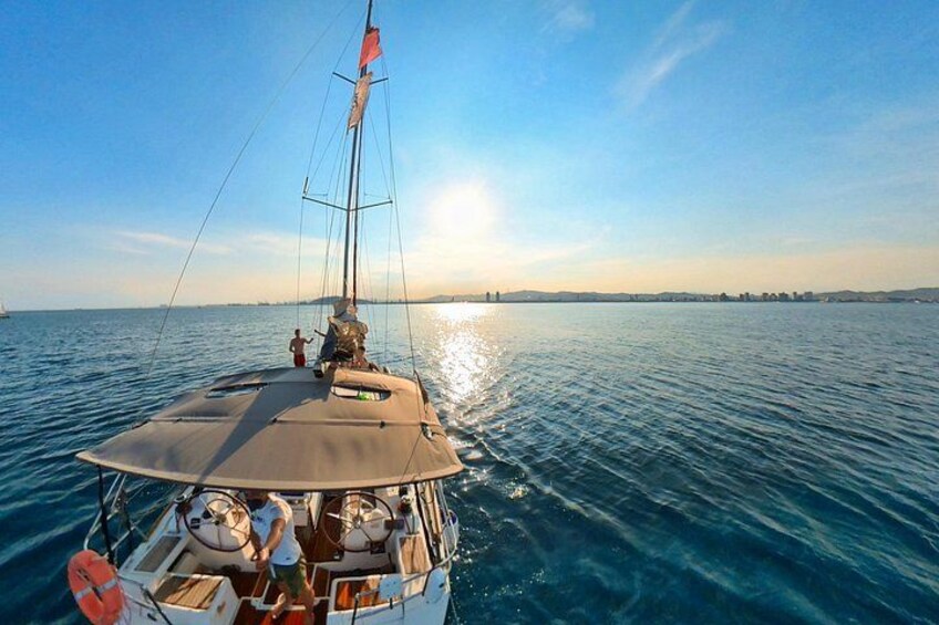 Una barca a vela su acque calme, cielo sereno e terraferma in lontananza. 5